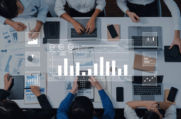 A diverse business team collaborates in a modern office, analyzing data trends with technology while discussing strategies and insights on multiple devices and charts. Trope