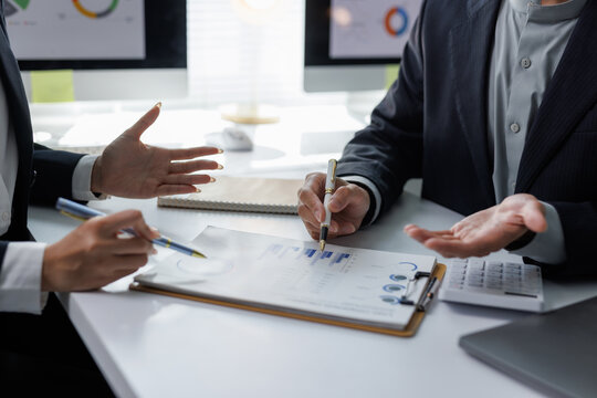 Business professionals analyzing financial data reports in office - Powered by Adobe