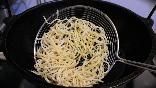 crispy fried noodles outside kadhai on stainer. 