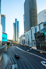 Obraz premium A city street with tall buildings and cars driving down it