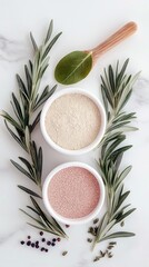 Two white bowls filled with different colored powders, surrounded by fresh rosemary sprigs and scattered spices on a white marble background. A wooden spoon wit
