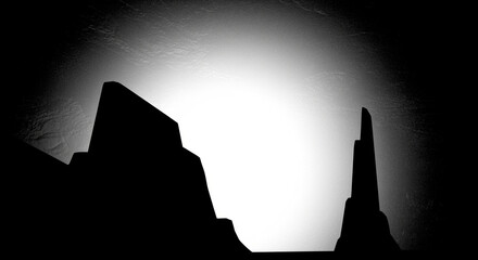 Dramatic Black and White Desert Landscape Silhouette with Towering Rock Formations and Brilliant Backlight