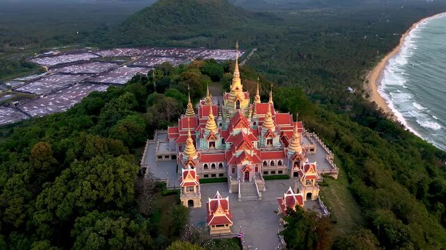 Phra Mahathat Chedi Phakdee Prakat Temple sits majestically atop Thong Chai Hill, overlooking lush greenery and the serene coastline of Thailand. This ornate temple offers breathtaking views.