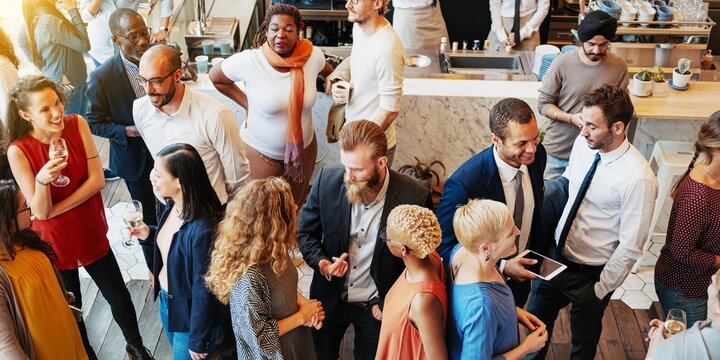 Diverse group at a social event, people mingling and networking. Mixed gender and ethnicity, lively atmosphere, business and casual attire, social gathering. Diverse business people mingle at event.