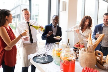 Group enjoying a casual gathering with drinks and food. Diverse mix of people socializing, sharing wine and snacks in a bright, modern setting. Diverse people mingle at social event at restaurant.