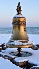 Ornate Brass Bell Covered in Snow Amidst a Winter Seascape with Frozen Waves and Icy Shoreline at Dawn