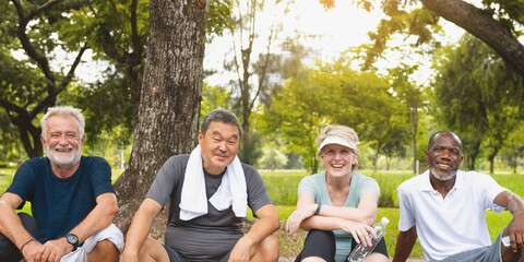 Group of four diverse seniors relaxing in a park. Friends enjoying nature. Happy seniors bonding. Multicultural elderly group in nature. Healthy diverse seniors exercising together at the park.