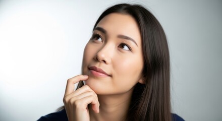 Contemplative young woman with smooth skin and long dark hair gazing thoughtfully to the side