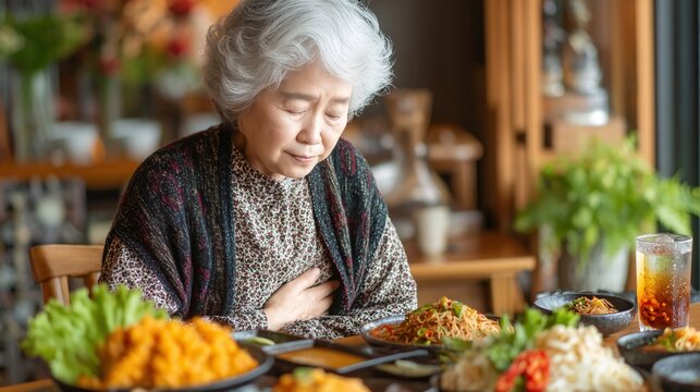 Elderly Woman Praying Before Meal in Traditional Asian Restaurant