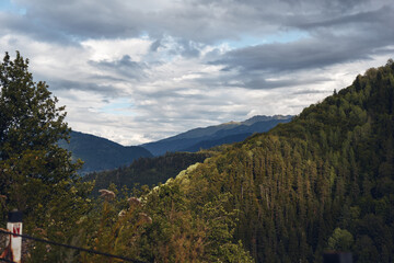 Landscape of rolling mountains and dense trees under a cloudy sky, offering a tranquil countryside scene with valley views and natural scenery today