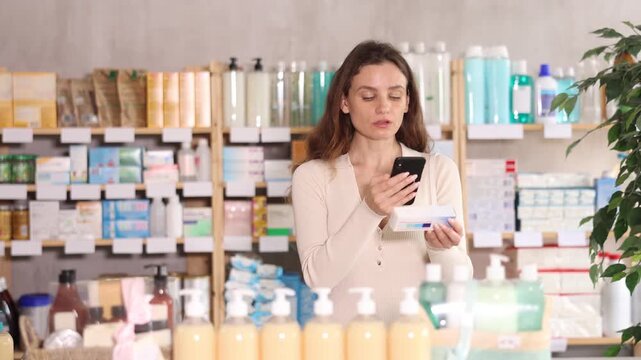  Adult woman buyer scanning qr code for box of ointment in pharmacy