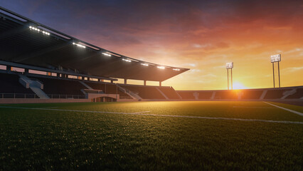 Empty sports stadium with bright lights at sunset, casting a warm glow over the green field and spectator stands.