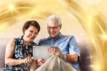Senior couple using a digital device in a living room