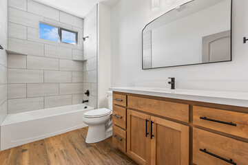 A spacious bathroom featuring two sinks, two mirrors, and a bathtub