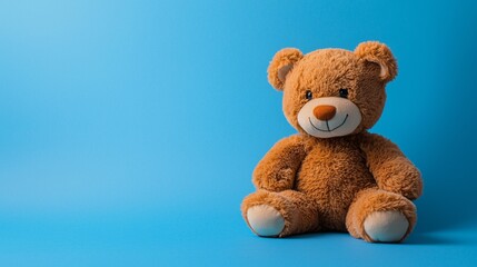 Soft teddy bear sitting on a blue background ready for a child's embrace and warm cuddles