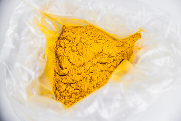 raw Curcuma powder in transparent container, medical spicy aroma, glass jar, plastic bag, isolated...