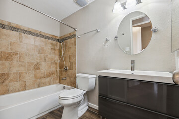 A wellequipped bathroom featuring a toilet, sink, bathtub, and a mirror