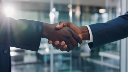 Two businessmen shake hands confidently in bright glass office environment with warm sunlight illuminating professional atmosphere - Powered by Adobe
