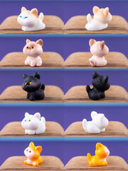 Close-up of small, cute figurines of multi-colored adorable kittens, placed on a wooden podium.