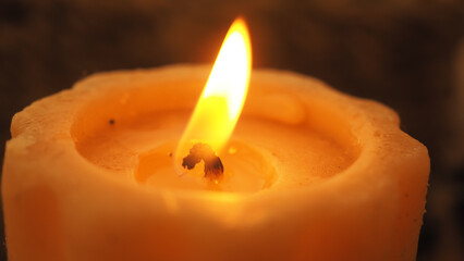 Warm glow of a candle flame flickering softly at dusk