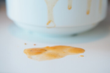 soup spill on a white surface with stains below
