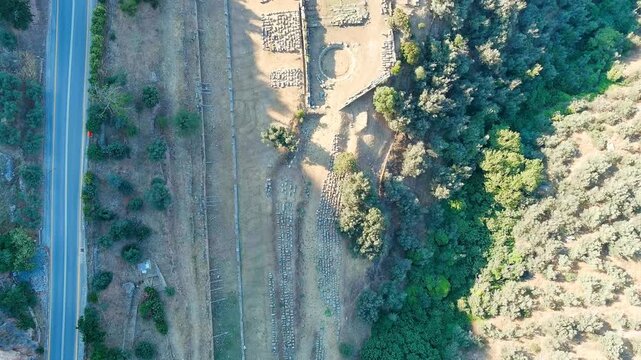 Delphi, Greece. Ruins of the ancient city of Delphi. Sunny weather in the morning, Summer. Drone footage, HEAD OVER SHOT