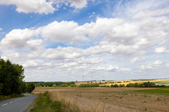 Epernay, Marne, Grand-Est, France, August, 28th, 2025, Champagne Area, Vast farmland stretching under expansive sky, Serene countryside road amid cultivated fields under wide clouds