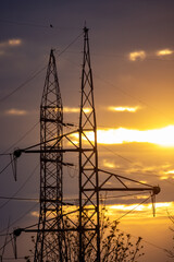Sunset power structures, Atmospheric dusk scene featuring towering power lines and metal structures under glowing sunset