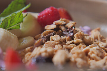 Delicious granola with fruits and fresh mint leaves