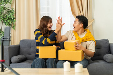 Happy couple celebrating online shopping delivery with cardboard boxes on sofa