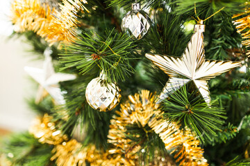christmas tree with gold and silver decorations including stars and tinsel