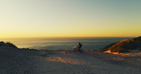 Man, cycling and mountain bike with beach sunset for outdoor journey or adventure in nature. Active, male person or cyclist with bicycle, ocean view or mockup space for ride, exercise or travel