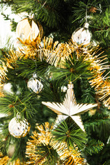 christmas tree with gold and silver decorations including stars and tinsel
