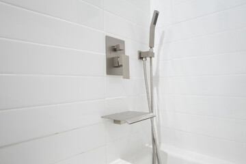 Interior detail featuring a vent panel centered on bright white tiled bathroom wall, showcasing refined textures, modern finishes, clean lines, and contemporary visual elements throughout the updated