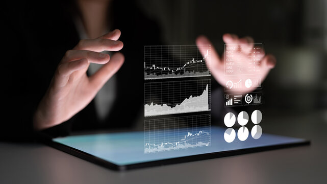 Business professional engages with digital data visualizations on a tablet, highlighting interaction with statistics and charts in a modern office environment. Impute