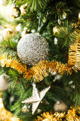 christmas tree with gold and silver decorations including stars and tinsel