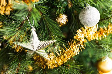 christmas tree with gold and silver decorations including stars and tinsel