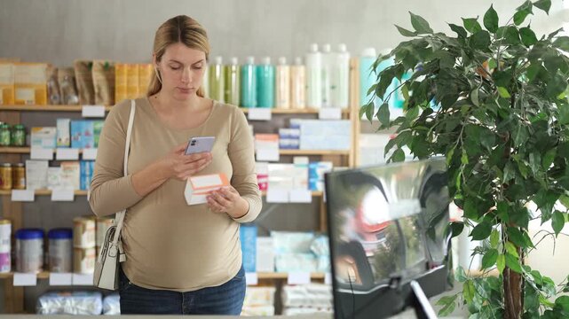 Pregnant woman in pharmacy scans QR code on vitamin pills product, studies product in detail, collects information online. Client learns information about product, reviews and recommendations for use