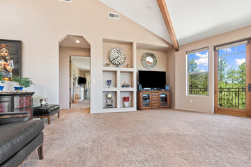 A spacious living room featuring a vaulted ceiling and a flat screen tv
