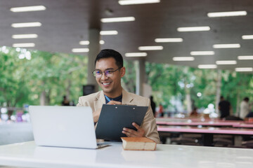 Asian man smiling during video call in modern library