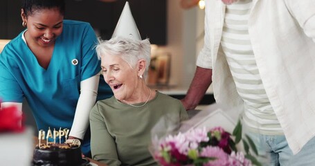 Birthday, cake and flowers with senior woman in retirement home for celebration, party or surprise. Bouquet of roses, gift or kiss with nurse and old couple in apartment together for milestone