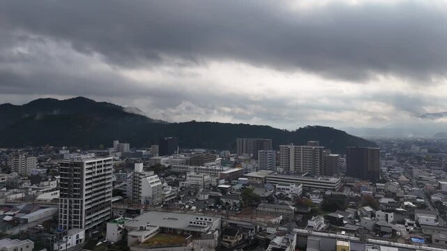 日本のドローン映像　地方都市と曇り空を上昇しながら空撮
