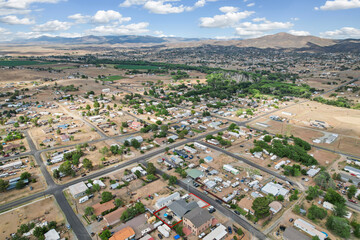 Fototapeta premium Aerial view shows a small town with majestic mountains behind