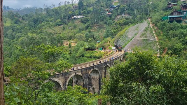 Scenic view of the Nine Arch Bridge in Ella, Sri Lanka, the famous &ldquo;Bridge in the Sky,&rdquo; with a train crossing its graceful colonial-era arches amid lush highland jungle