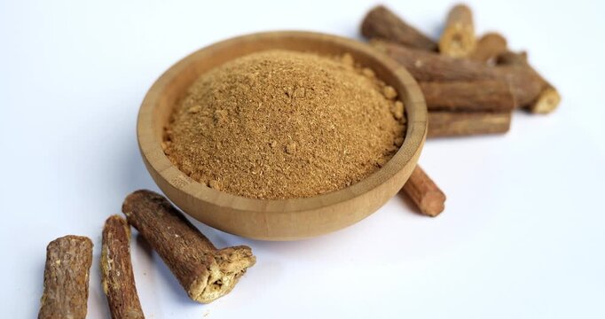 Ayurvedic Mulethi or Liquorice root stick or jeshthamadh powder served in a bowl over moody background