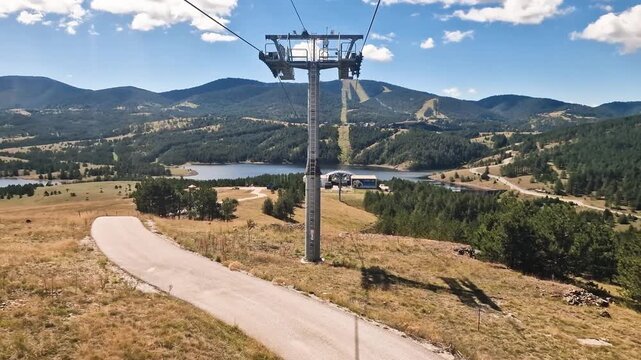 Gondola Lift Moving Above Road and Hills, Passenger Point of View of Tower and Cables. Zlatibor, Serbia