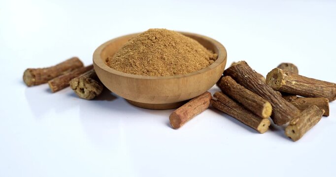 Ayurvedic Mulethi or Liquorice root stick or jeshthamadh powder served in a bowl over moody background