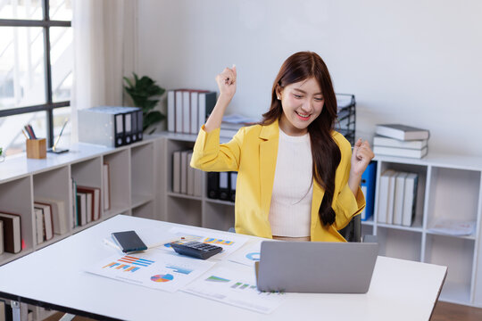 Young businesswoman celebrating success achieving online goals