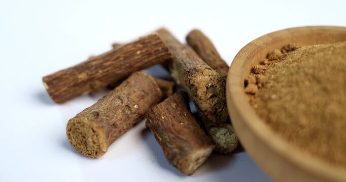 Ayurvedic Mulethi or Liquorice root stick or jeshthamadh powder served in a bowl over moody background