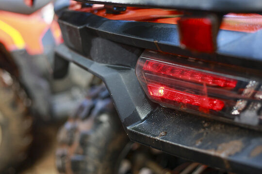 Close up rear red tail light of black all terrain vehicle. powerful ATV quad bike ready for an outdoor off road adventure, showing transport and modern LED technology